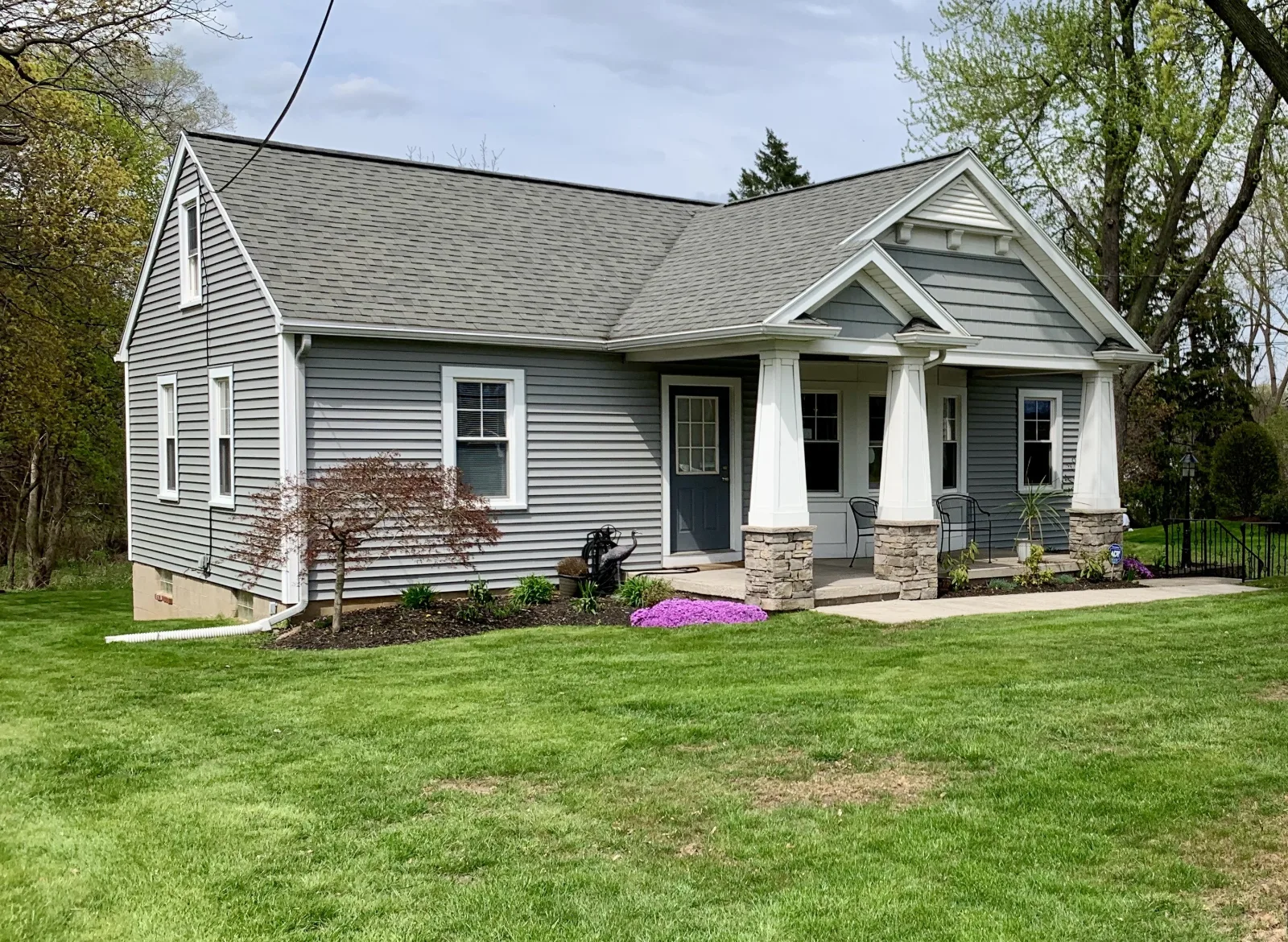 The salon: a gray house with a white-pillared front porch, set back on a lawn