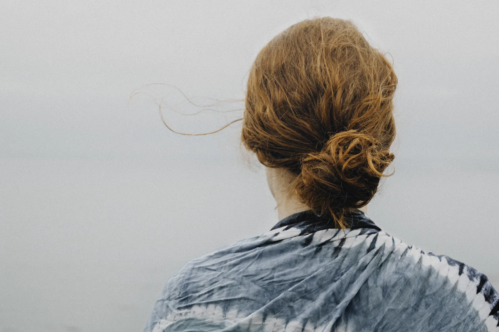 Red hair pinned up in a loose bun, seen from behind